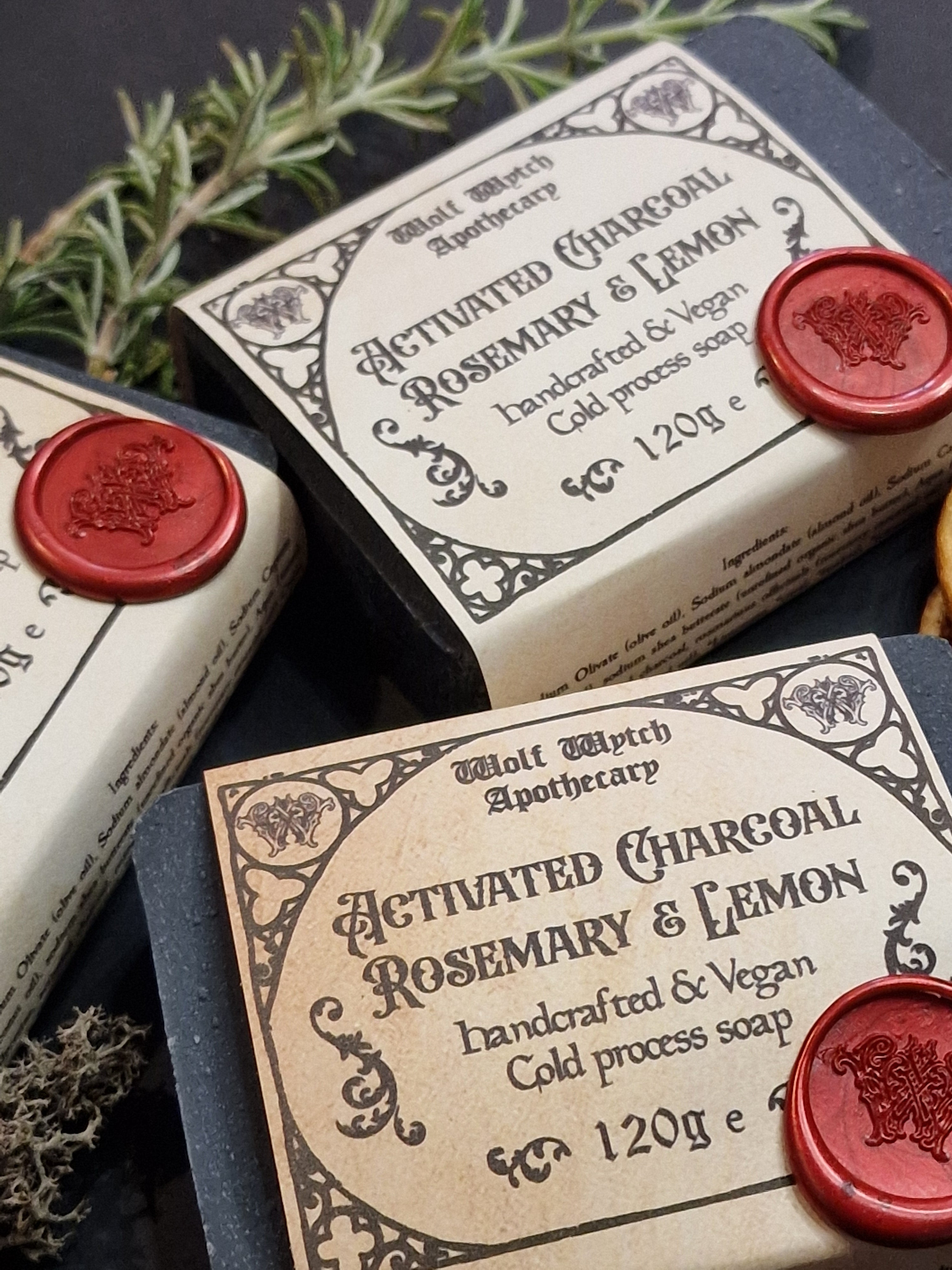 Three bars of soap with decorative labels and red wax seals on a dark background.
